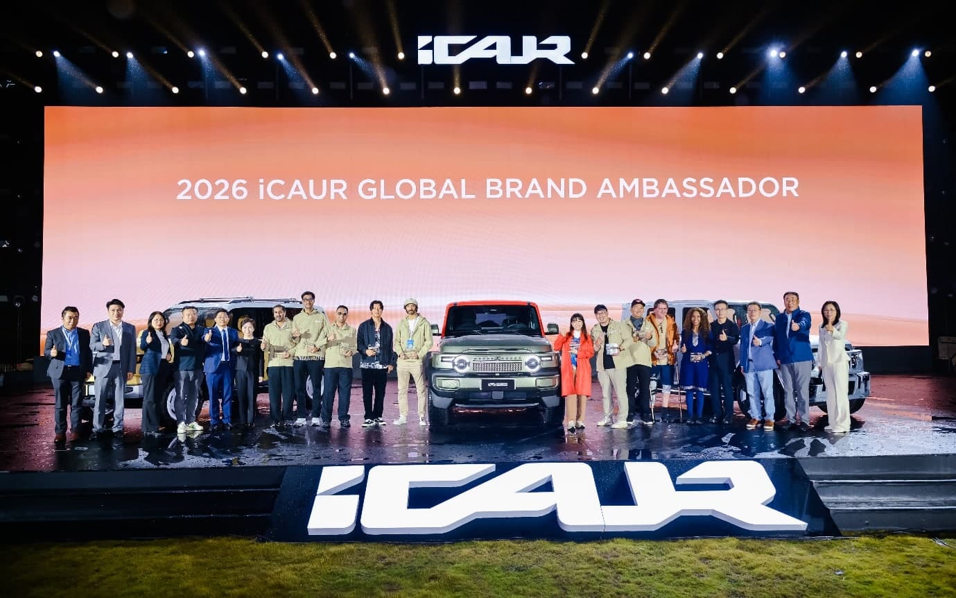 The first iCAUR global brand ambassadors and company representatives pose beside a vehicle on the summit stage.